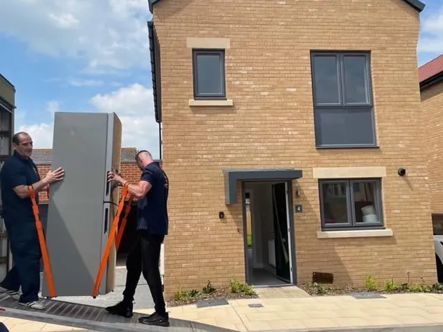 Reliable Removals crew delivering an American fridge freezer up the van ramp
