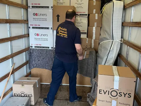 Reliable Removals mover stacking packed cartons inside the van