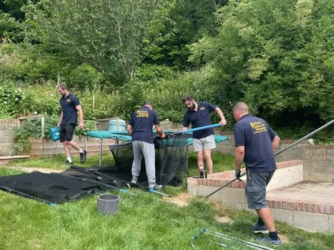 Reliable Removals team dismantling a garden trampoline